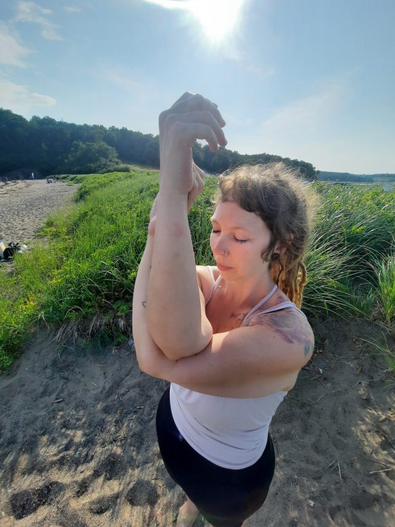 A yoga practitioner practices an embodied pose outdoors in natural light, reflecting Cove Yoga’s focus on presence, ritual, and mindful movement.