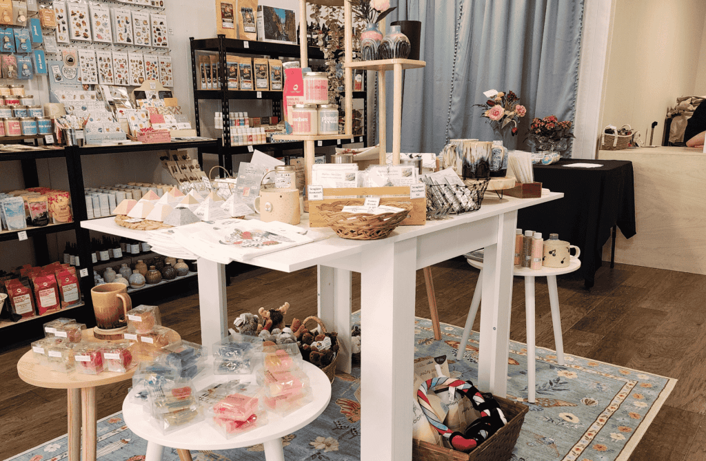Curated display table inside Memory Made Gifts featuring candles, pottery, and handmade goods from Canadian small businesses in Uptown Saint John.