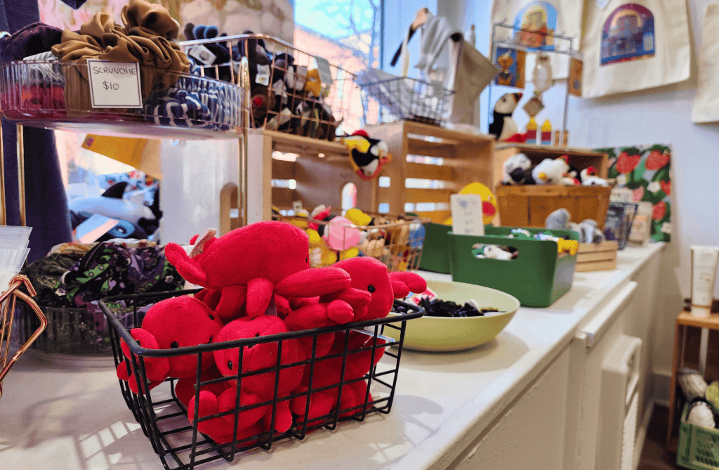 Close-up of small gifts and souvenirs including plush toys and accessories arranged on a display table inside Memory Made Gifts.