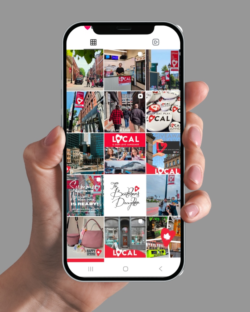 Phone displaying Uptown Saint John Local Love social media campaign featuring businesses, banners, and community engagement posts.