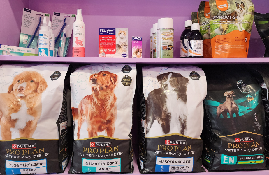 Shelf display of Purina Pro Plan veterinary diet pet food and pet care products inside Uptown Animal Clinic.