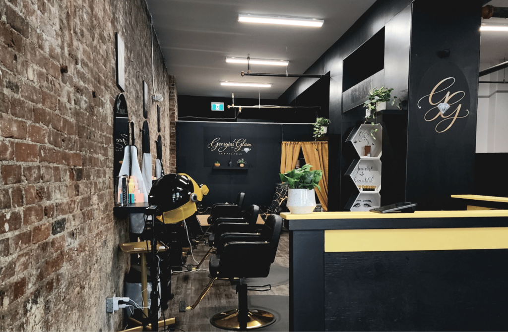 View through the interior of Georgia's Glam showing styling stations and historic brick walls.